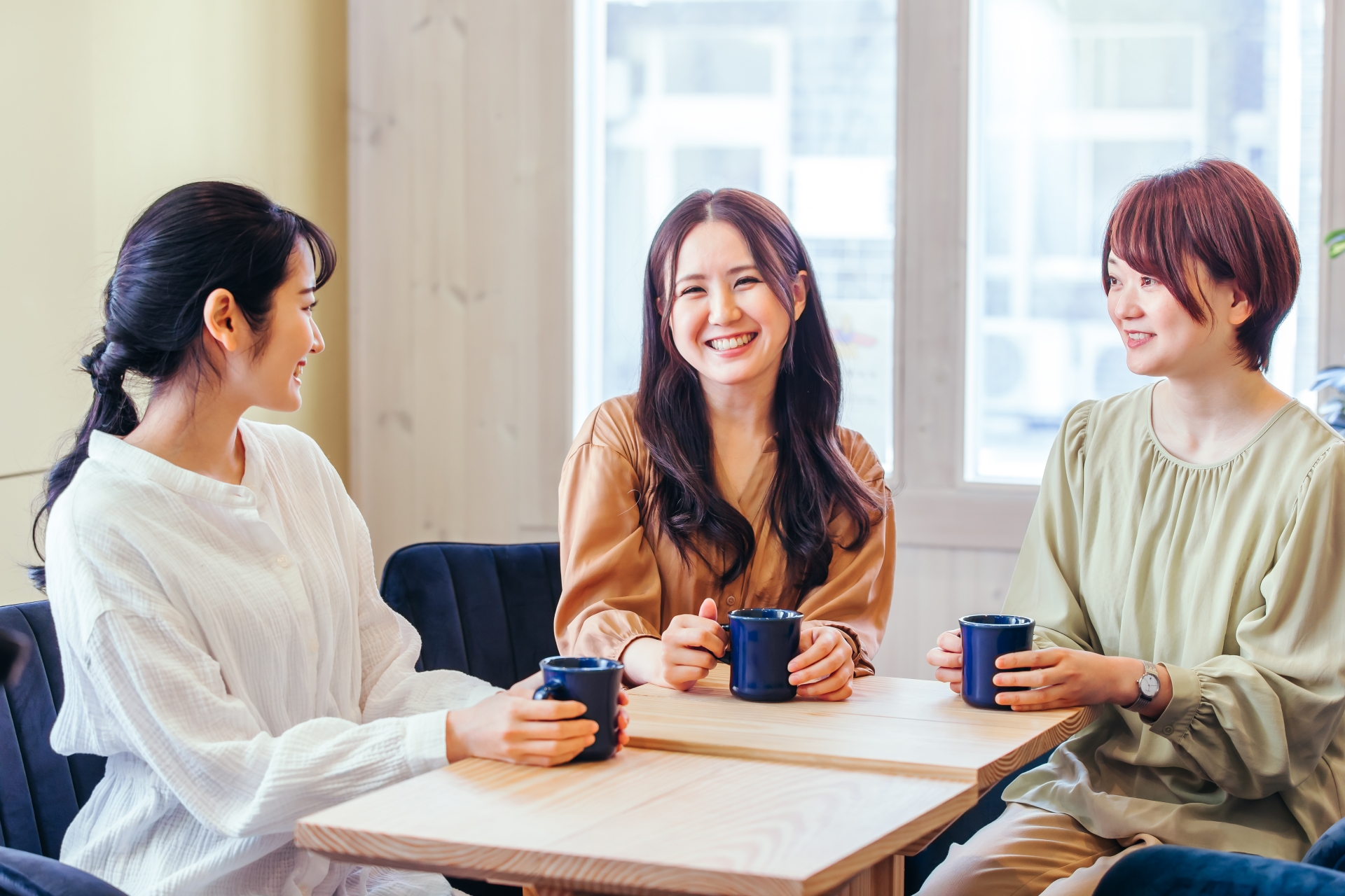 談笑しながらお茶をする女性3人の写真